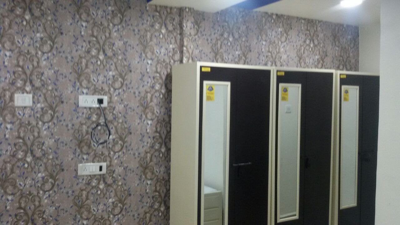 Room with wardrobes and patterned wallpaper at The Aura