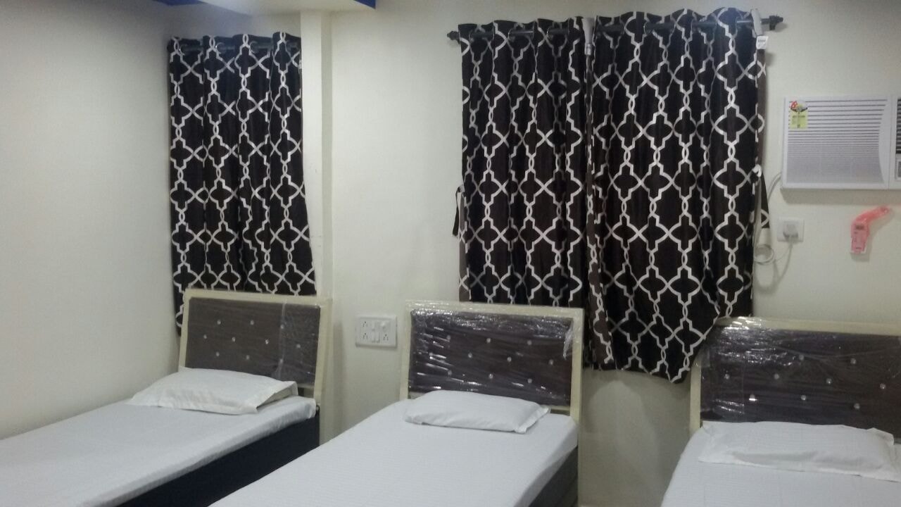 Triple sharing room with black curtains at The Aura