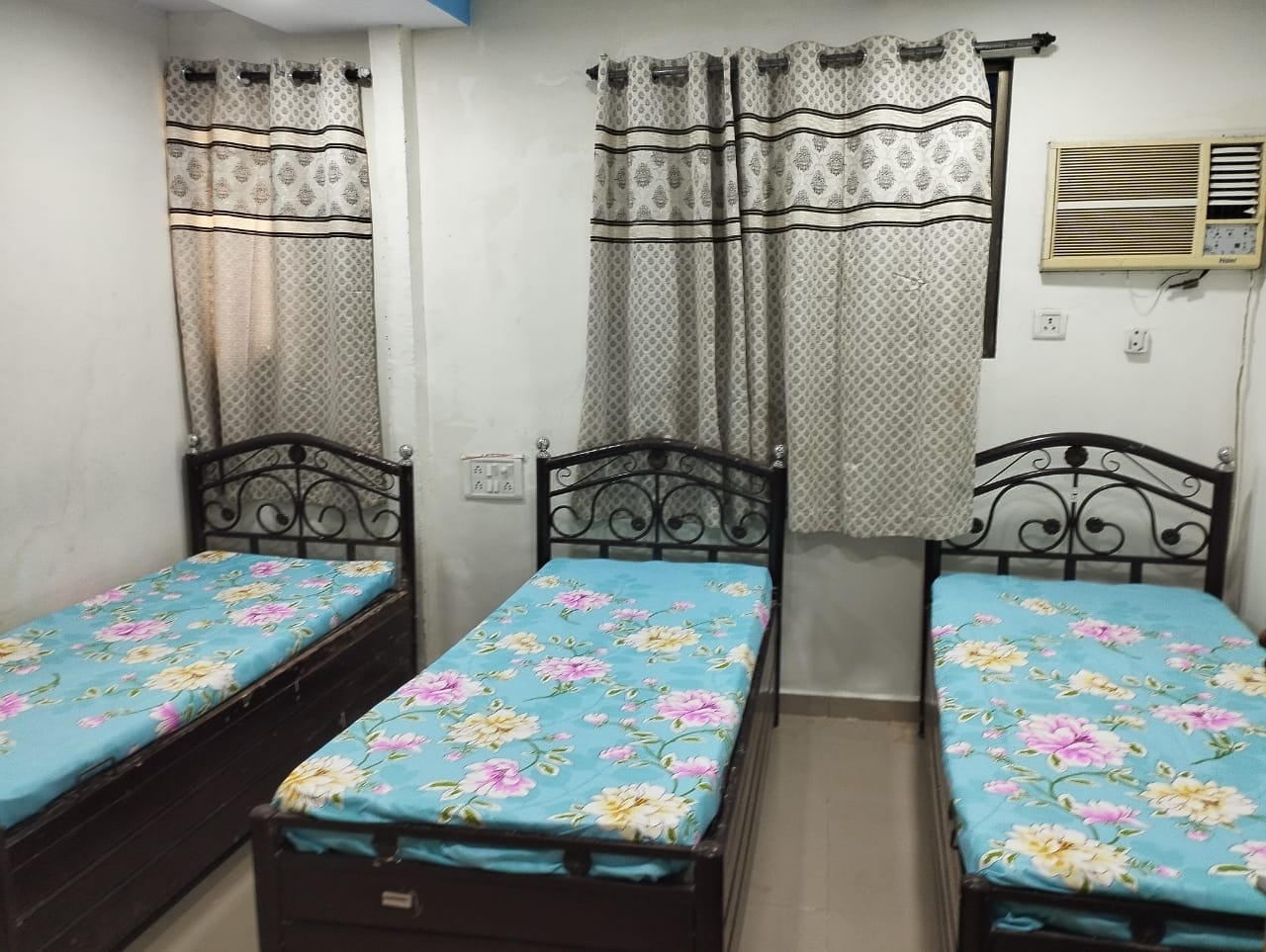 Triple sharing room with iron beds at The Aura